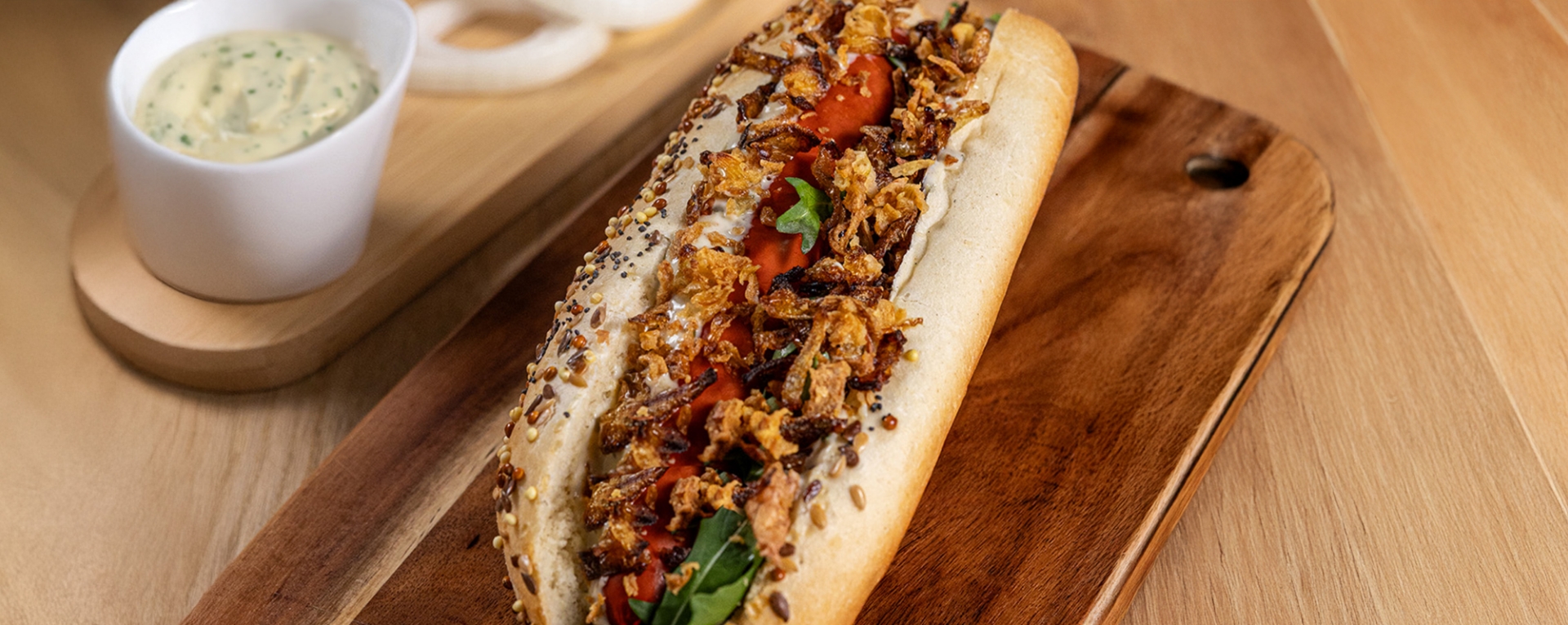 Hot-dog gourmand avec oignons ORION fondants et saucisse grillée