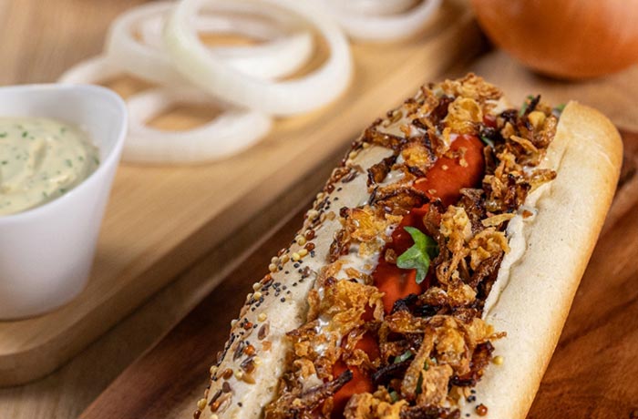 Hot-dog gourmand avec oignons ORION fondants et saucisse grillée