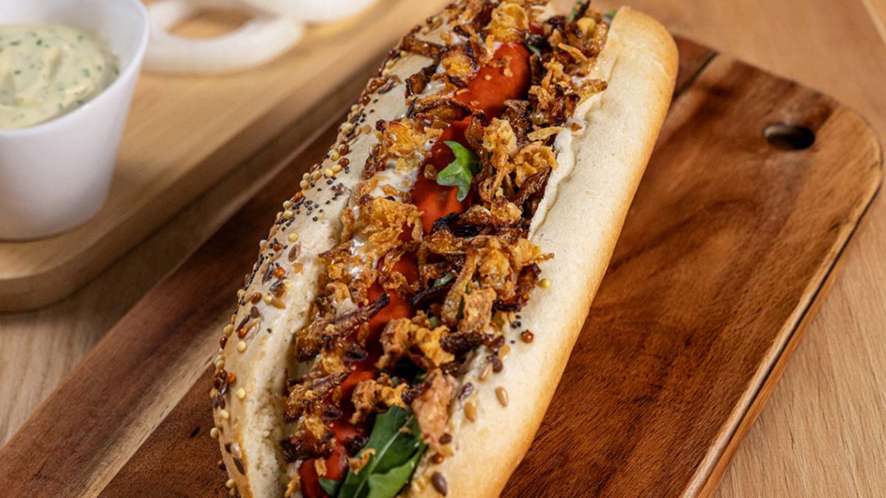 Hot-dog gourmand avec oignons ORION fondants et saucisse grillée